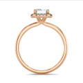 1.00 carat solitaire halo ring with a emerald cut diamond in red gold with round diamonds