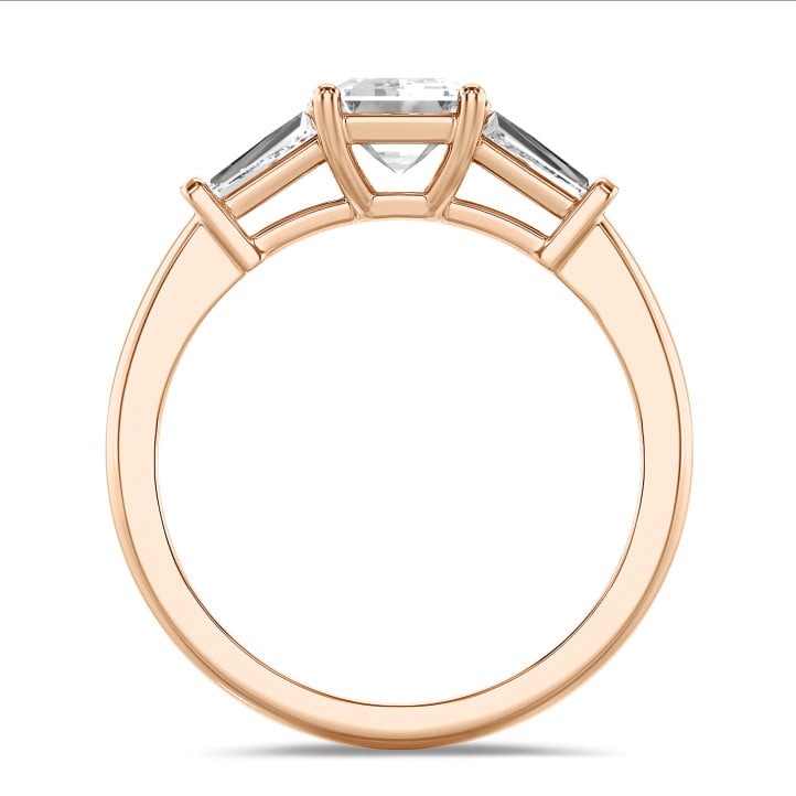 1.00 carat trilogy ring in red gold with a lab grown emerald cut diamond and lab gown tapered baguettes