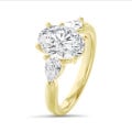 Anillo trilogía con un diamante oval de 3,00 quilates y diamantes pera laterales de 0,35 quilates cada uno en oro amarillo