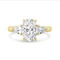Anillo trilogía con un diamante oval de 3,00 quilates y diamantes pera laterales de 0,35 quilates cada uno en oro amarillo