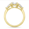 Anillo trilogía con un diamante oval de 3,00 quilates y diamantes pera laterales de 0,35 quilates cada uno en oro amarillo