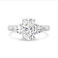 Bague trilogie en platine avec un diamant ovale de 3.00 carats et deux diamants en forme de poire de 0.35 carat chacun.