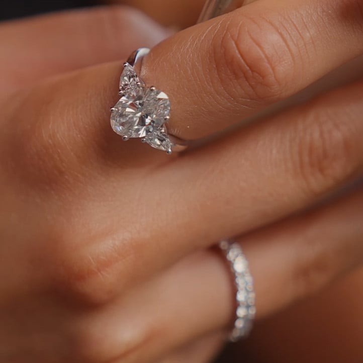 Bague trilogie en or jaune avec un diamant ovale de 3.00 carats et deux diamants en forme de poire de 0.35 carat chacun.