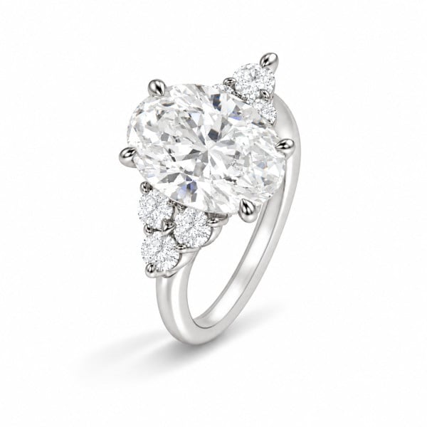 Bague sur mesure ornée d'un diamant taille ovale et entourée de pierres rondes en pavage.