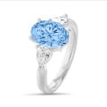 Anello trilogy unico nel suo genere con un diamante ovale blu intenso intenso da 2,00 carati con diamanti bianchi laterali a goccia da 0,30 carati ciascuno in oro bianco