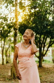 elderly woman wearing diamond earrings and necklace and enjoying the sun