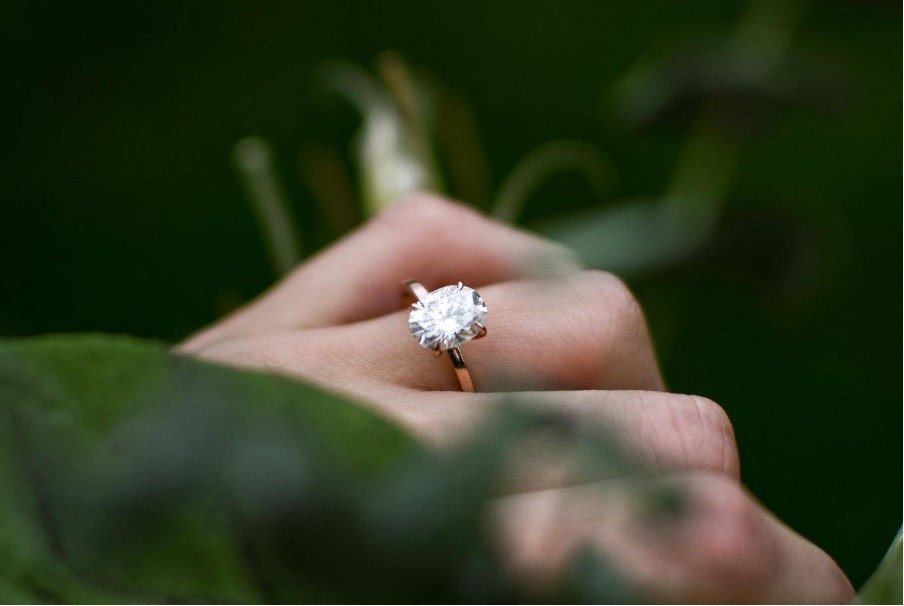 Femme à l'extérieur portant une bague en diamant blanc à l'annulaire