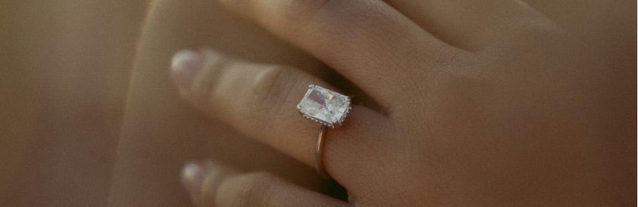 Vrouw met een emerald geslepen witte diamanten ring