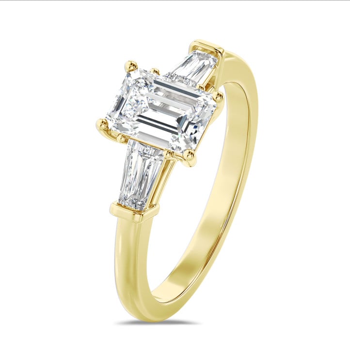 Laboratuvarda üretilmiş zümrüt kesim elmas ve laboratuvarda üretilmiş konik baget taşlarla süslenmiş, sarı altın 3,00 karatlık üçlü yüzük